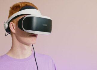 A young caucasian man wearing VR glasses, experiencing virtual reality.
