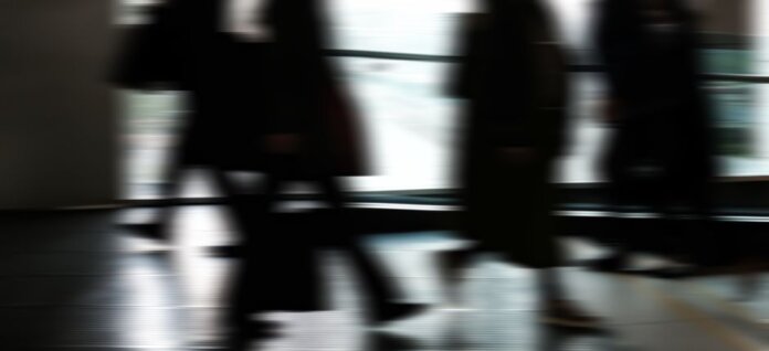 Abstract blurred motion of people walking indoors, depicting urban life and busy routines. Abstract blurred motion of people walking indoors, depicting urban life and busy routines.