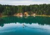 Места для каякинга с прокатом в Трай-Ситис, куда легко добраться на транспорте Aerial shot of a woman paddle boarding on a serene lake in Rezh, Russia, surrounded by lush greenery.
