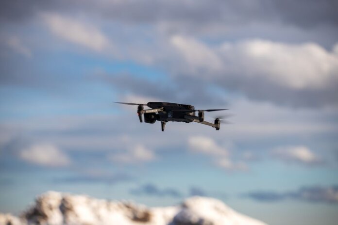 Aerial view of a drone flying over snow-covered mountains with dramatic clouds. Aerial view of a drone flying over snow-covered mountains with dramatic clouds.
