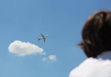 Исследование: самые раздражающие привычки пассажиров в самолётах An airplane flies high in a clear sky while a person watches from below.