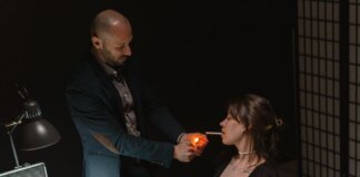 An intense scene depicting a suspect lighting a cigarette during an interrogation.