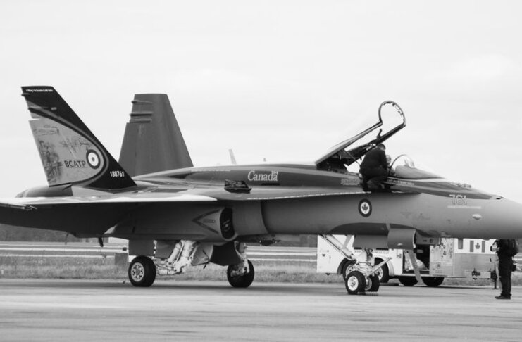 Canadian fighter jet on airstrip. Monochrome image showcasing aviation and military theme.