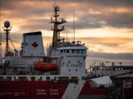 Close-up of a Canadian Coast Guard ship docked at sunset, showcasing maritime details.