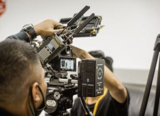 Close-up of advanced filmmaking equipment being used by professionals indoors.