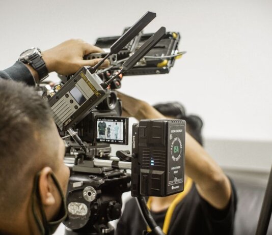 Close-up of advanced filmmaking equipment being used by professionals indoors.