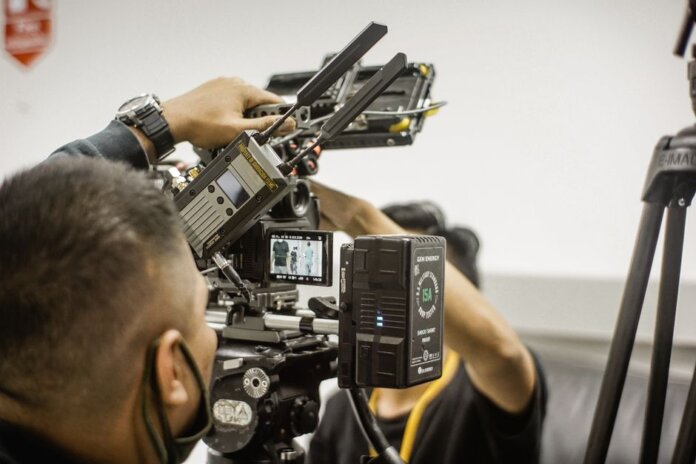 Close-up of advanced filmmaking equipment being used by professionals indoors. Close-up of advanced filmmaking equipment being used by professionals indoors.
