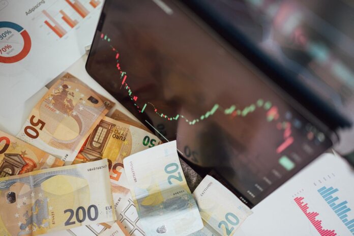 Close-up of euro banknotes with a digital stock market chart displaying a downward trend, symbolizing financial volatility. Close-up of euro banknotes with a digital stock market chart displaying a downward trend, symbolizing financial volatility.