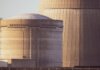 Close-up view of nuclear reactor buildings bathed in golden light, showcasing industrial architecture.