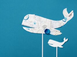 Conceptual image of a whale shape made from recycled plastic on a bright blue background.