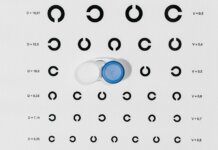 Contact lens case on top of eye test chart for optometric examinations.