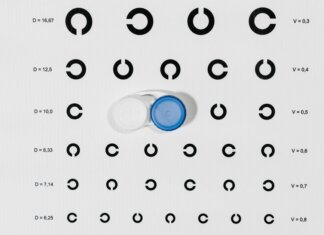 Contact lens case on top of eye test chart for optometric examinations.