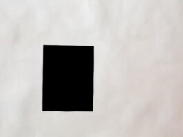 Creative black mock up rectangular paper sheet with copy space attached on white wall in light room of modern studio