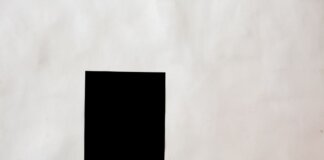 Creative black mock up rectangular paper sheet with copy space attached on white wall in light room of modern studio