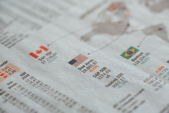 Detailed close-up of a newspaper displaying global financial market statistics and country flags. Detailed close-up of a newspaper displaying global financial market statistics and country flags.