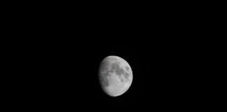 Detailed photograph of a waxing gibbous moon against a dark night sky, showcasing lunar features.