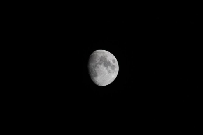 Detailed photograph of a waxing gibbous moon against a dark night sky, showcasing lunar features. Detailed photograph of a waxing gibbous moon against a dark night sky, showcasing lunar features.