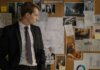 Арест женщины за использование фальшивых денег в магазинах Онтарио Detective in suit examining evidence on cork board during investigation process.
