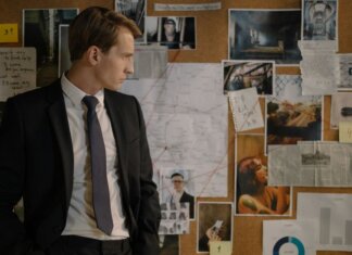 Арест женщины за использование фальшивых денег в магазинах Онтарио Detective in suit examining evidence on cork board during investigation process.