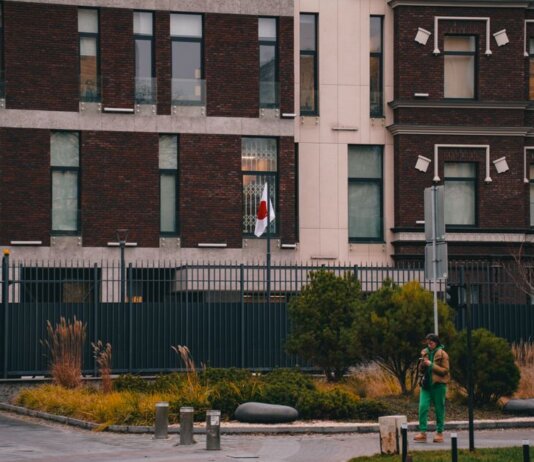 Exterior of the Japanese Embassy in Kyiv, featuring the national flag and urban landscape.