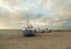 Учёные из Западного университета изучают вулканы Луны на Гавайях Fishing boats anchored on the sandy shores of Thisted, Denmark during a calm sunset.