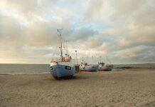 Учёные из Западного университета изучают вулканы Луны на Гавайях Fishing boats anchored on the sandy shores of Thisted, Denmark during a calm sunset.