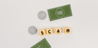 Flat lay of fake currency and scam letters on a gray surface representing financial deception.