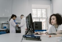 Исследователи Университета Западного Онтарио получили $19 млн грантов Focused woman working on a computer in a busy laboratory setting, showcasing teamwork and scientific research.