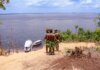Береговая охрана выделила $1,6 млн коренным общинам на лодки Indigenous men in traditional attire overlooking boats on the Amazon River.