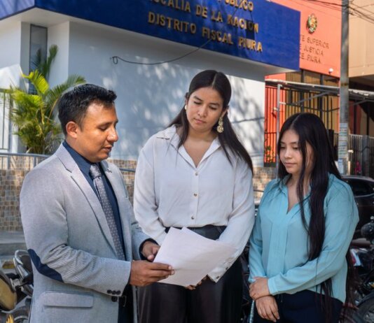 Legal consultation outside the Piura District Office, Piura, Peru. People discussing documents.