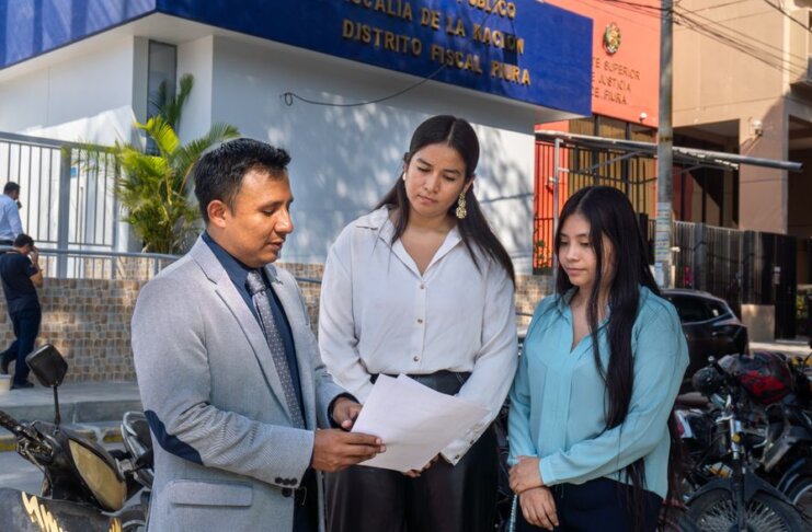 Legal consultation outside the Piura District Office, Piura, Peru. People discussing documents.