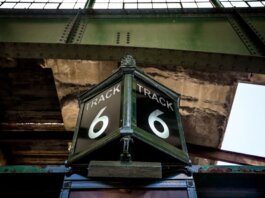 Low angle view of a vintage Track 6 sign at a railway station, showcasing rustic industrial architecture.