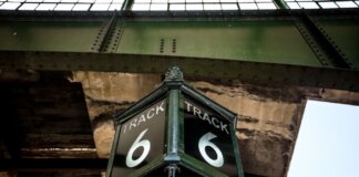 Low angle view of a vintage Track 6 sign at a railway station, showcasing rustic industrial architecture.