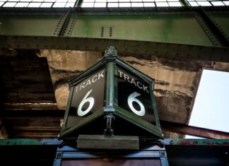 Low angle view of a vintage Track 6 sign at a railway station, showcasing rustic industrial architecture.
