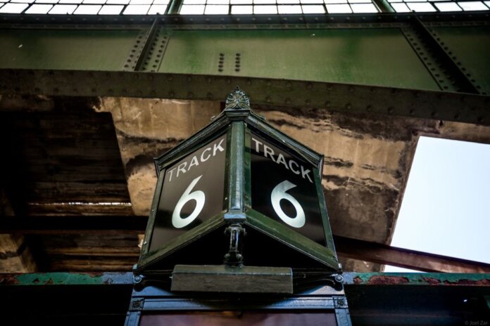 Low angle view of a vintage Track 6 sign at a railway station, showcasing rustic industrial architecture. Low angle view of a vintage Track 6 sign at a railway station, showcasing rustic industrial architecture.
