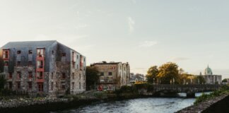 Picturesque view of the river in Galway, Ireland at sunset with historic buildings and a charming bridge.