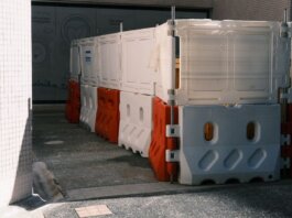 Plastic roadblock barriers with red and white colors in an urban area.