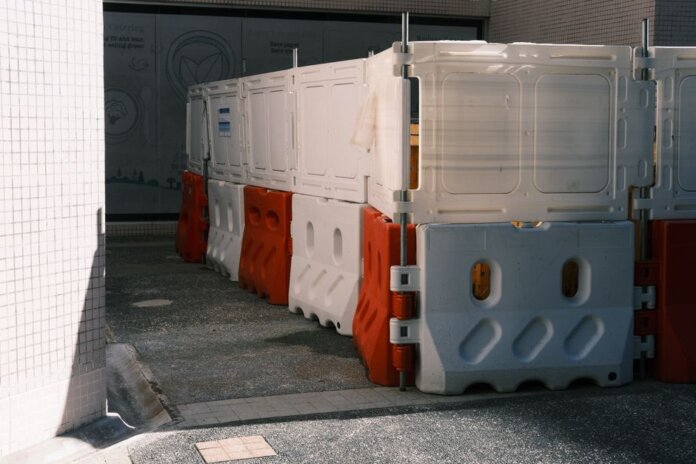 Plastic roadblock barriers with red and white colors in an urban area. Plastic roadblock barriers with red and white colors in an urban area.