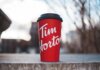 Пять главных итогов вдохновляющего выступления Канады на ЧМ-2026 Red Tim Horton coffee cup placed on a concrete surface with a blurred outdoor background.
