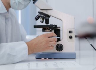 Реконструкция отделения неотложной помощи в Сент-Джонсе завершена Researcher analyzing samples with a microscope in a lab setting.