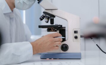 Реконструкция отделения неотложной помощи в Сент-Джонсе завершена Researcher analyzing samples with a microscope in a lab setting.