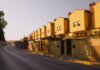 Строительство жилья в Канаде упало вдвое от обещанных темпов Row of yellow suburban houses under warm evening light, showcasing Mediterranean architecture.