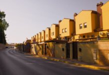 Строительство жилья в Канаде упало вдвое от обещанных темпов Row of yellow suburban houses under warm evening light, showcasing Mediterranean architecture.