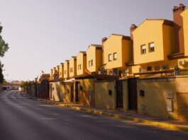 Row of yellow suburban houses under warm evening light, showcasing Mediterranean architecture.