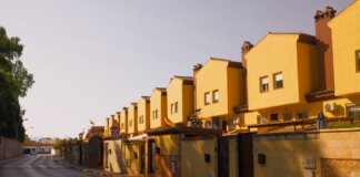 Row of yellow suburban houses under warm evening light, showcasing Mediterranean architecture.