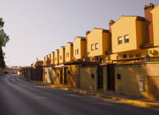 Строительство жилья в Канаде упало вдвое от обещанных темпов Row of yellow suburban houses under warm evening light, showcasing Mediterranean architecture.