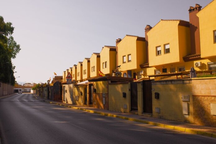 Row of yellow suburban houses under warm evening light, showcasing Mediterranean architecture. Row of yellow suburban houses under warm evening light, showcasing Mediterranean architecture.