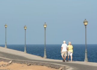 Ньюфаундленд и Лабрадор открыл прием заявок на гранты для пожилых Senior couple walking on a seaside promenade enjoying a peaceful day by the ocean.
