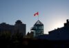 Playteck: 20 лет создания легкоатлетических дорожек в Канаде Silhouette of Winnipeg skyline with Canadian flag during sunset, showcasing modern architecture.