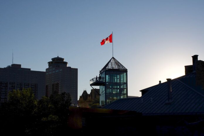 Silhouette of Winnipeg skyline with Canadian flag during sunset, showcasing modern architecture. Silhouette of Winnipeg skyline with Canadian flag during sunset, showcasing modern architecture.